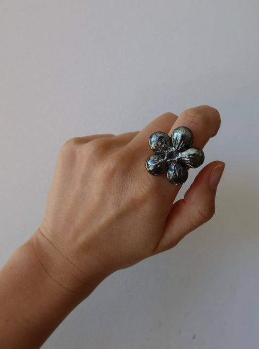 Bloom ceramic flower ring in deep silver iridescent glaze worn on model hand, handmade in Lisbon