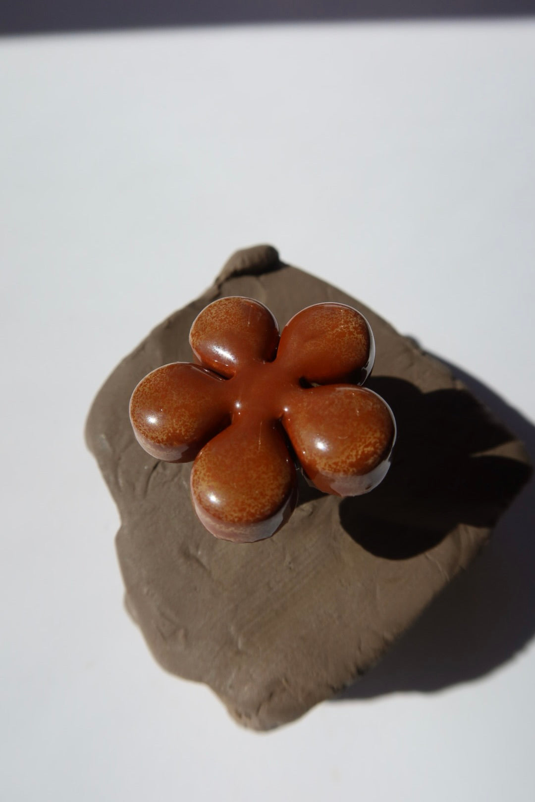 Sparkling brown ceramic flower ring on raw clay, made in Portugal