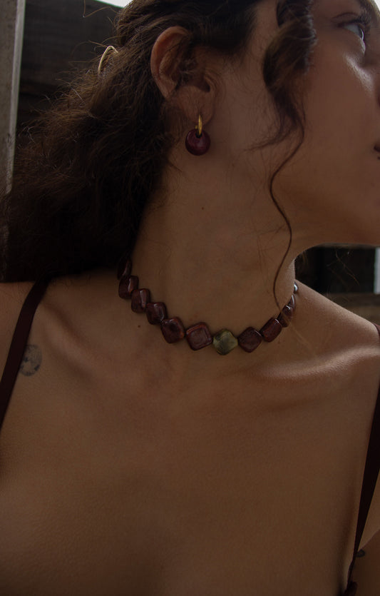 Gomes handmade ceramic earrings in Cherry worn by curly hair model — rounded circular form, bold yet discreet, made in Lisbon Portugal by Jadeo Studio