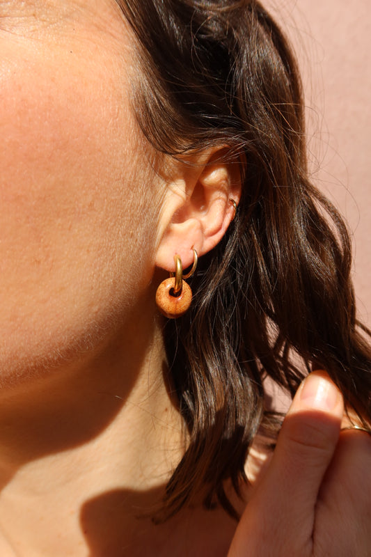 Gomes handmade ceramic earrings in Sparkling Brown worn with sunlight — rounded circular form, bold yet discreet, made in Lisbon Portugal by Jadeo Studio