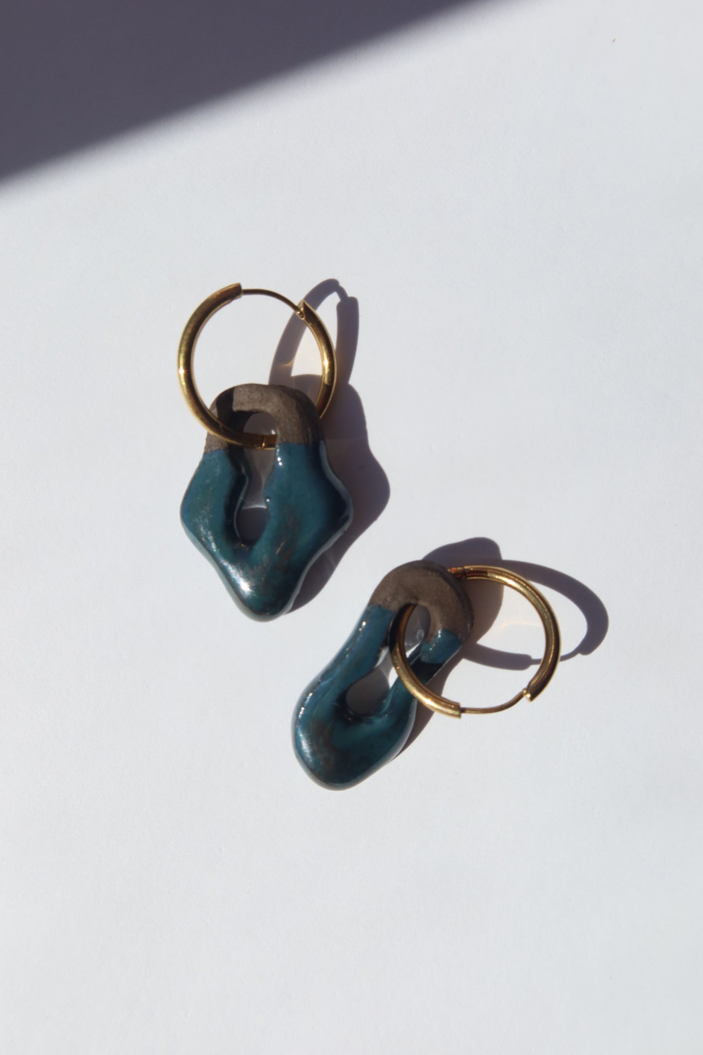 Mosca handmade ceramic earrings in Blue Green on Dark Clay — organic sculpted clay with glossy glaze, made in Lisbon Portugal by Jadeo Studio, silver and gold hoop