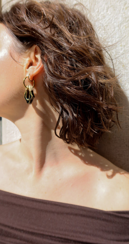 Mosca handmade ceramic earrings in Dark Green — organic sculpted clay with glossy glaze, made in Lisbon Portugal by Jadeo Studio, close-up with weavy hair