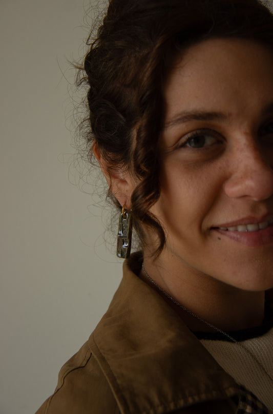Penha handmade ceramic earrings in Dark Green, worn by curly hair model — minimalist rectangular drop, sculpted clay, made in Lisbon Portugal by Jadeo Studio