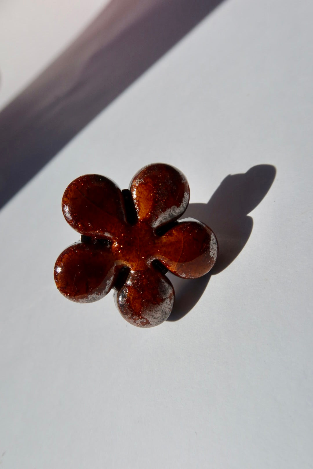 Bloom ceramic flower ring in deep bark amber glaze with copper shimmer, handmade in Lisbon