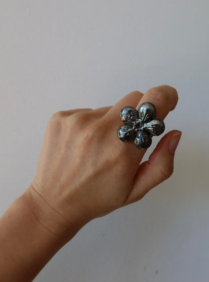 Bloom ceramic flower ring in deep silver iridescent glaze worn on model hand, handmade in Lisbon