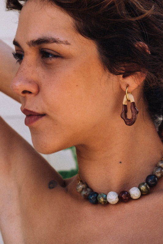 Handmade burgundy ceramic earrings worn — Mosca design with glossy glaze, sculpted clay by Jadeo Studio Lisbon