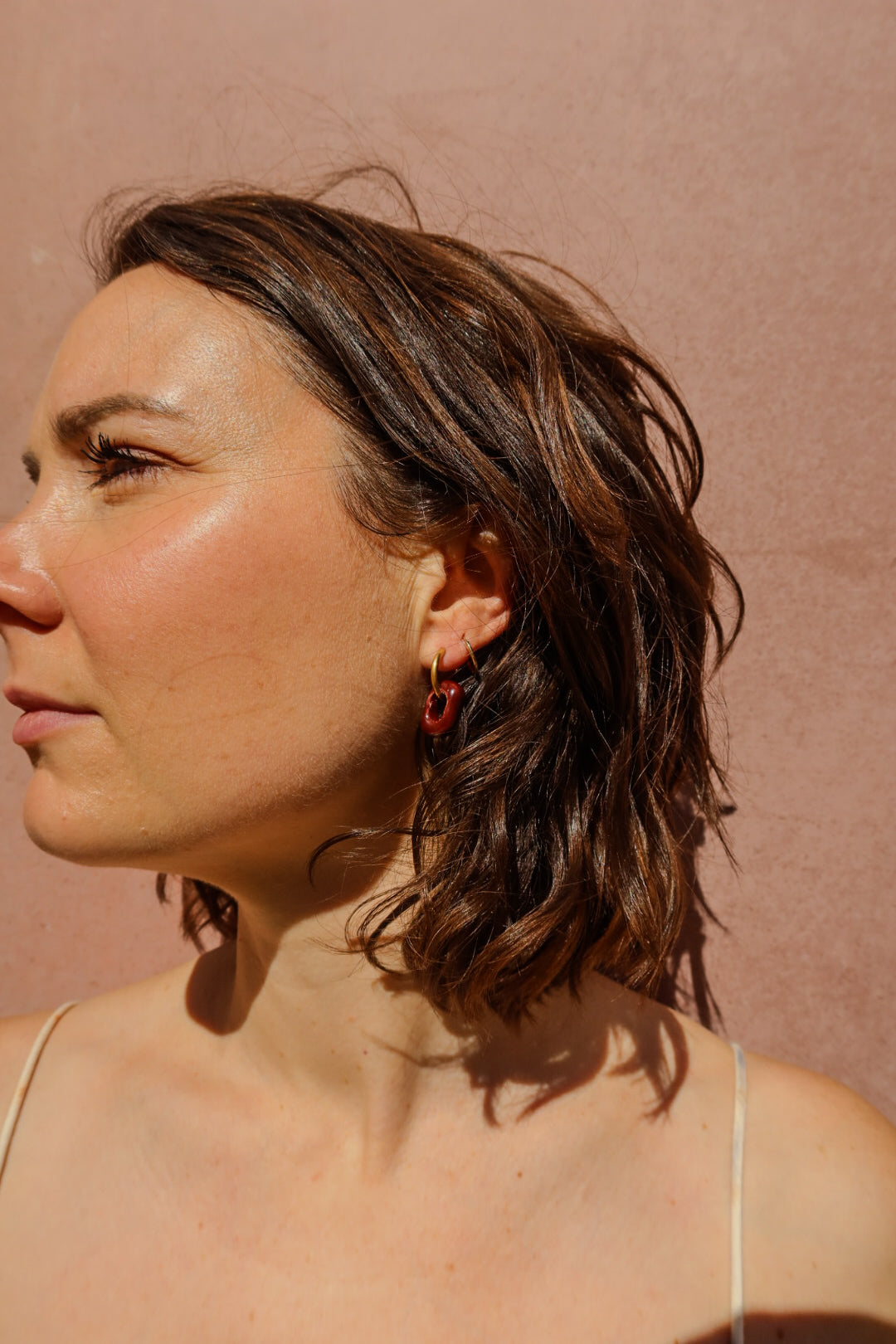 Azoia handmade ceramic earrings in Brown Red with sunlight — subtle small hoop, everyday elegance, made in Lisbon Portugal by Jadeo Studio