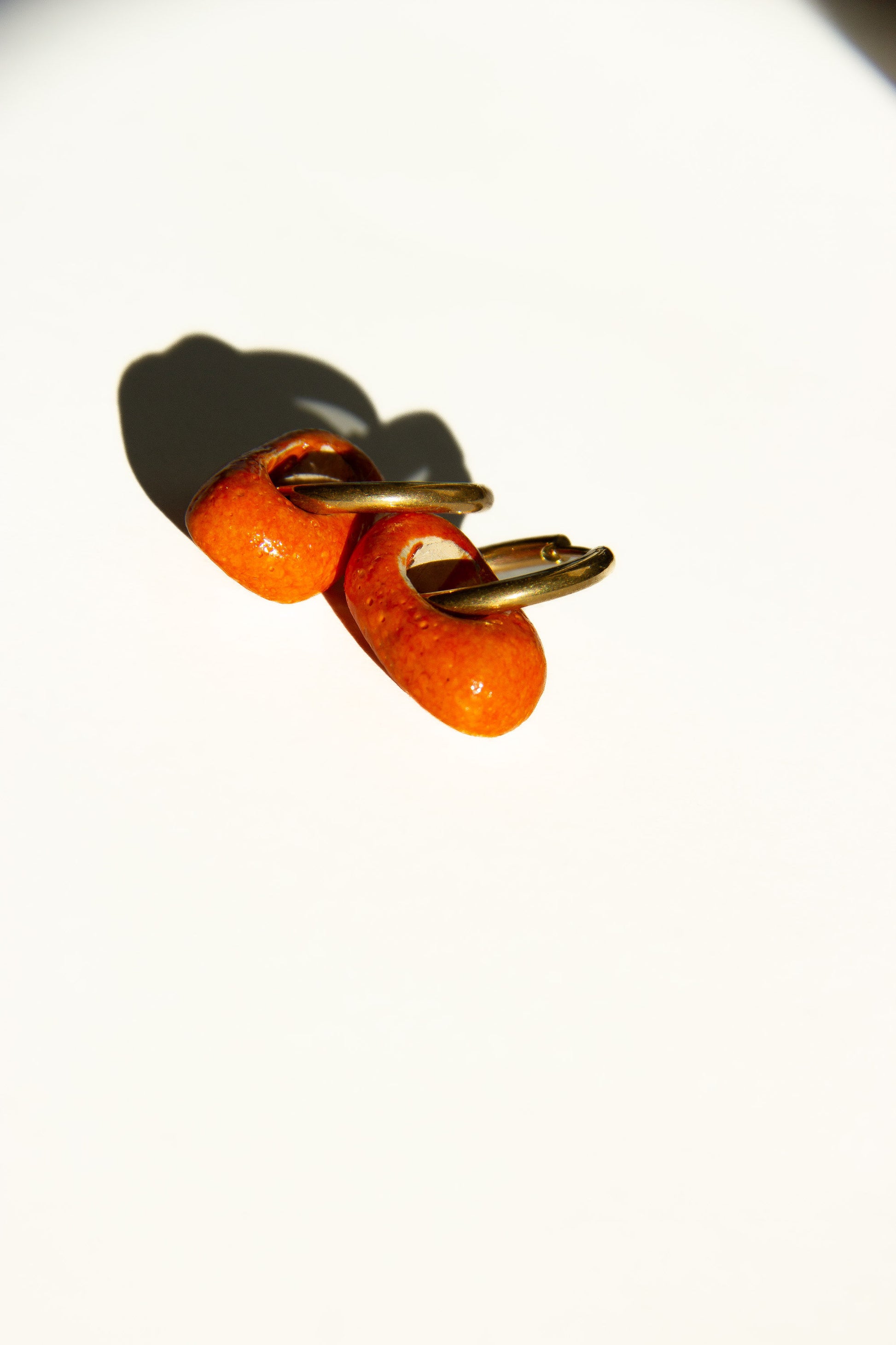 Azoia handmade ceramic earrings in Volcano — subtle small hoop, everyday elegance, made in Lisbon Portugal by Jadeo Studio, silver and golden hoop