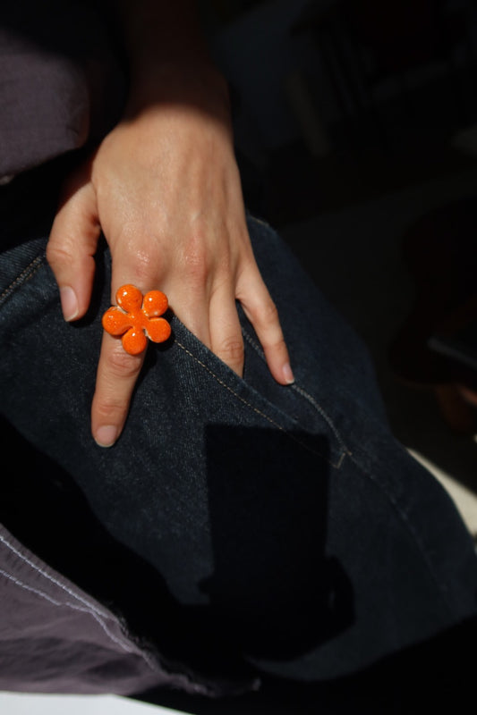 Bloom handmade ceramic flower ring in Volcano orange worn on summer outfit — bold statement ring inspired by Lisbon in spring, made in Portugal by Jadeo Studio