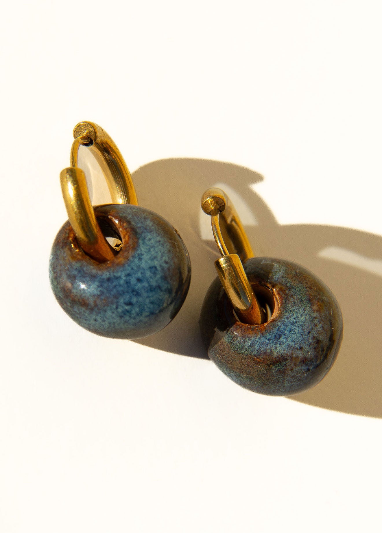 Gomes handmade ceramic earrings in Blue Jeans — rounded circular form, bold yet discreet, soft denim blue glaze, statement jewelry made in Lisbon Portugal by Jadeo Studio