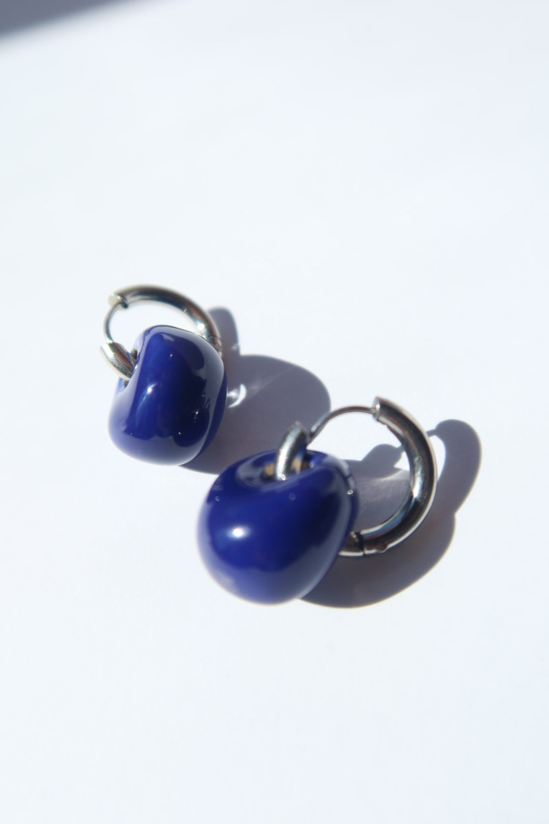 Gomes handmade ceramic earrings in Blue Navy, glossy glaze — rounded circular form, bold yet discreet, made in Lisbon Portugal by Jadeo Studio