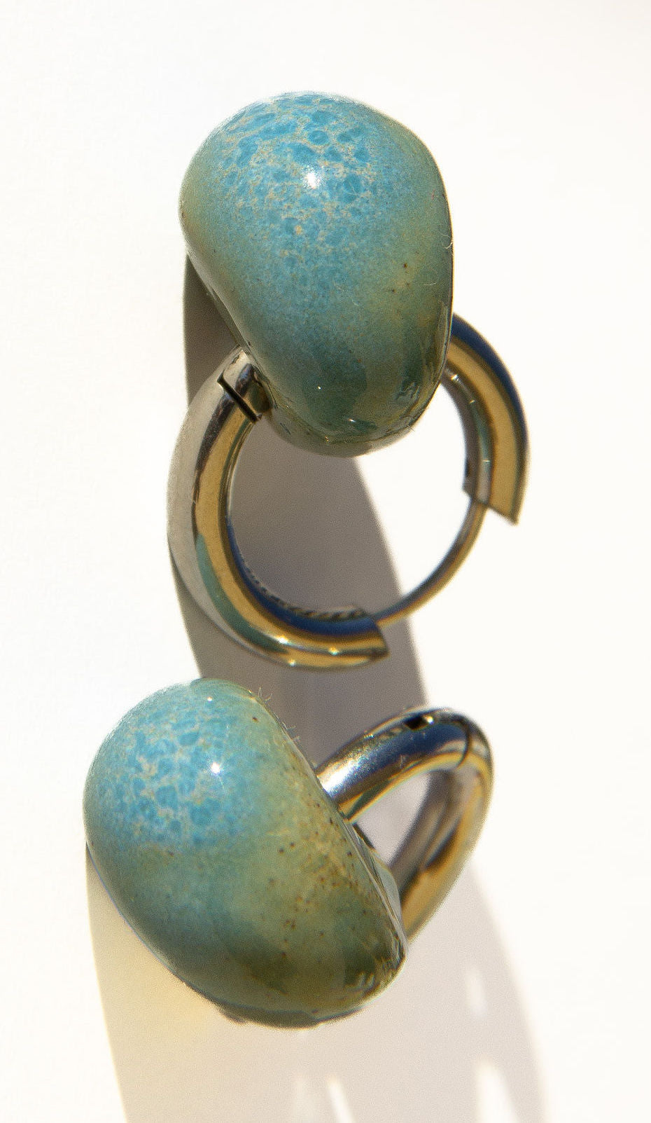 Gomes handmade ceramic earrings in Blue Sky, glossy glaze — rounded circular form, bold yet discreet, made in Lisbon Portugal by Jadeo Studio