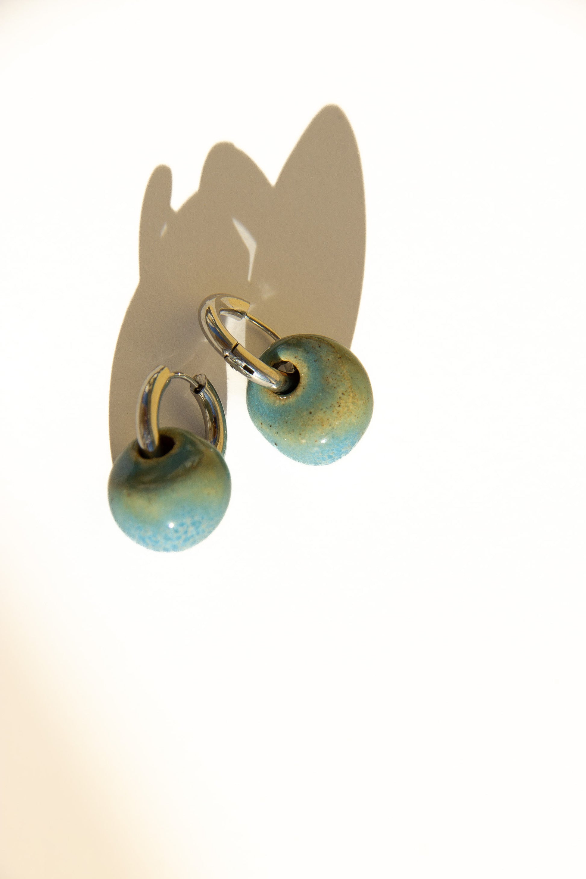Gomes handmade ceramic earrings in Blue Sky — rounded circular form, bold yet discreet, statement jewelry made in Lisbon Portugal by Jadeo Studio