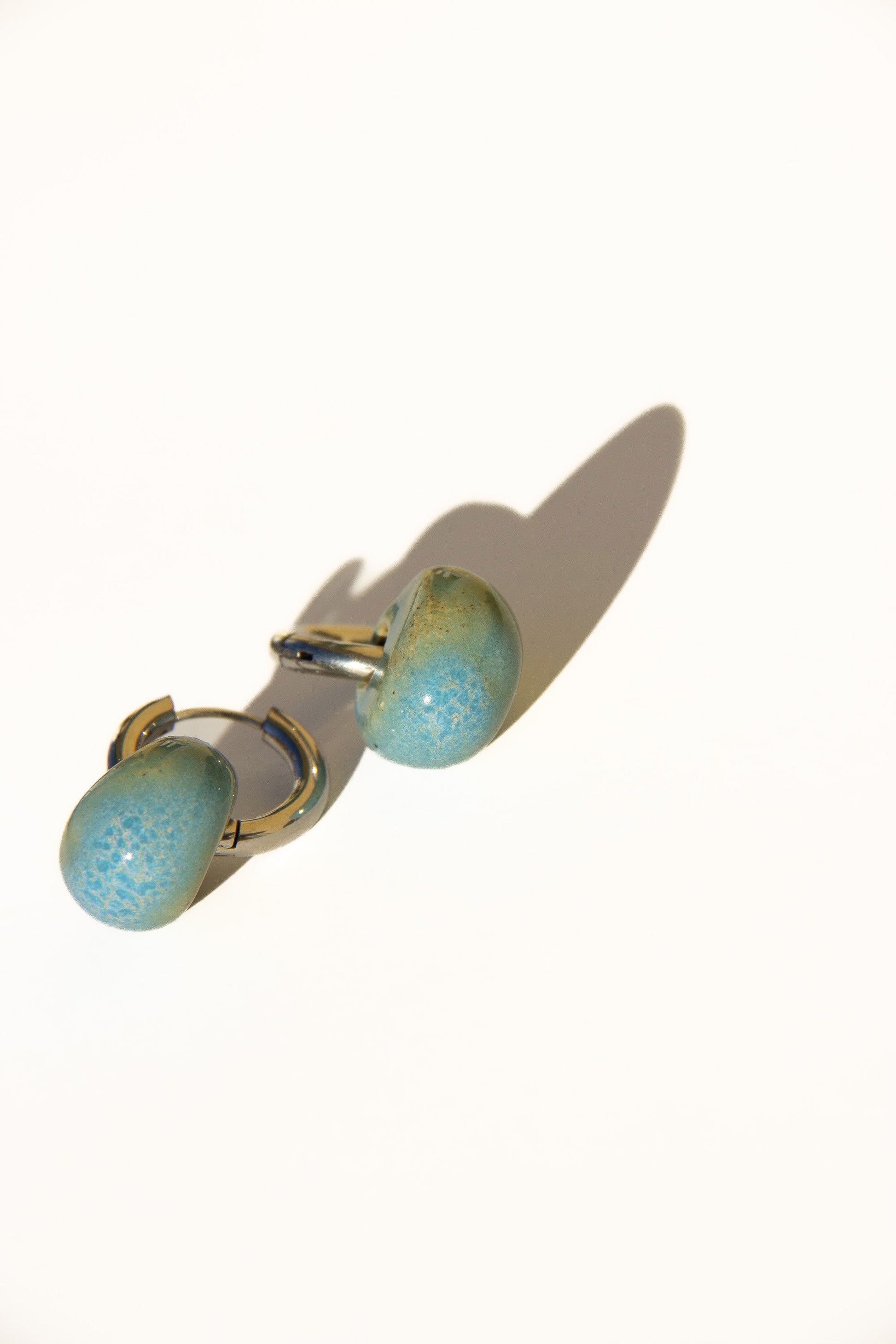 Gomes handmade ceramic earrings in Blue Sky — rounded circular form, bold yet discreet, made in Lisbon Portugal by Jadeo Studio