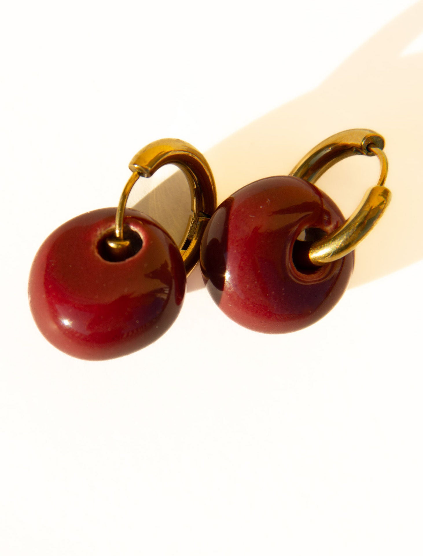 Gomes handmade ceramic earrings in Cherry, glossy glaze — rounded circular form, bold yet discreet, made in Lisbon Portugal by Jadeo Studio