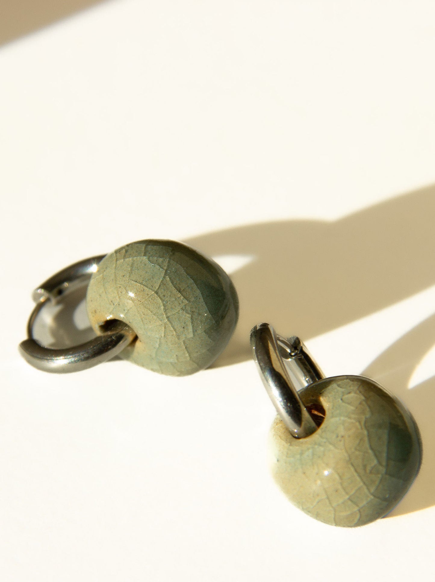 Gomes handmade ceramic earrings in Crackled Light Blue, glossy glaze — rounded circular form, bold yet discreet, made in Lisbon Portugal by Jadeo Studio