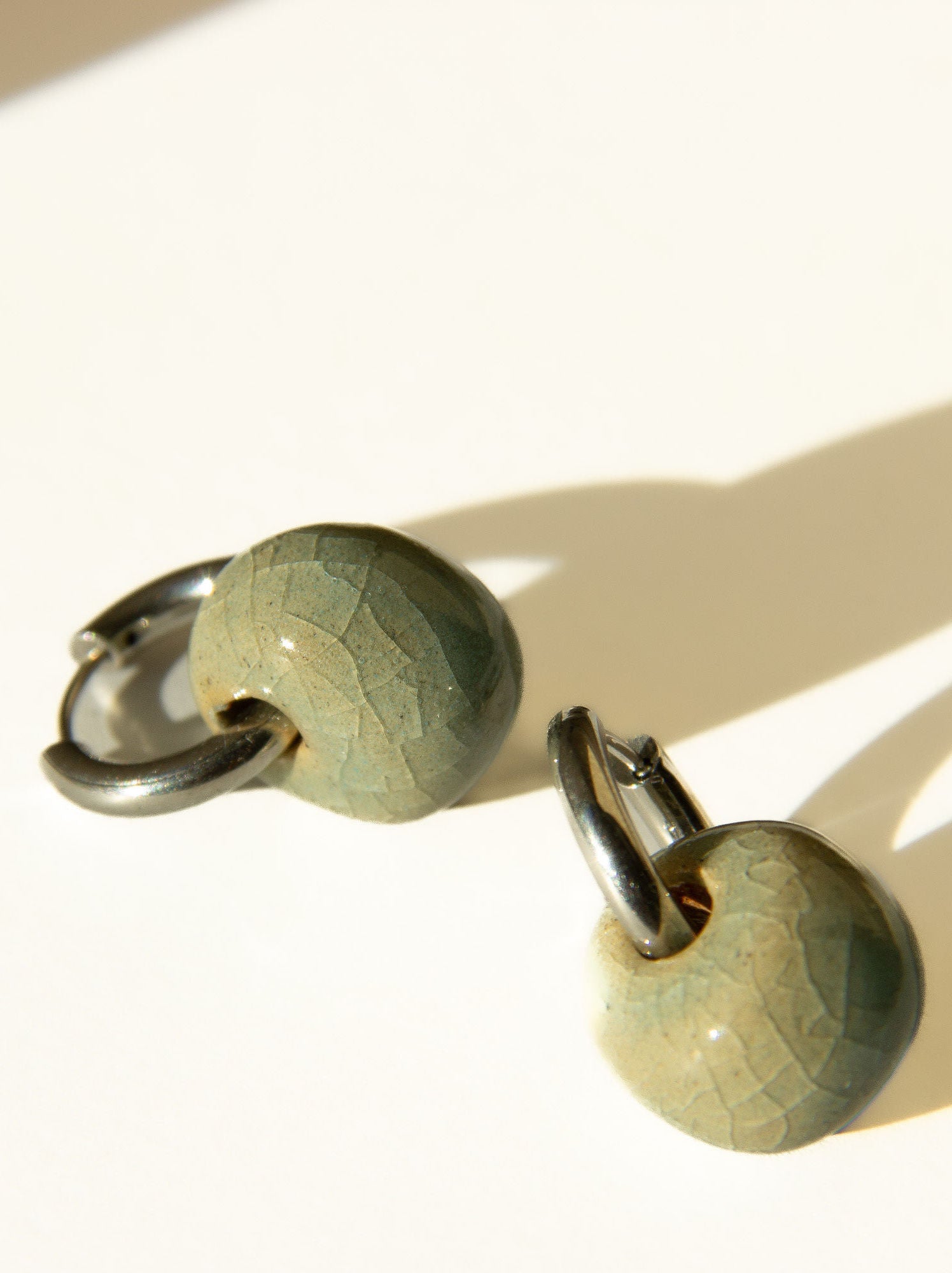 Gomes handmade ceramic earrings in Crackled Light Blue, glossy glaze — rounded circular form, bold yet discreet, made in Lisbon Portugal by Jadeo Studio