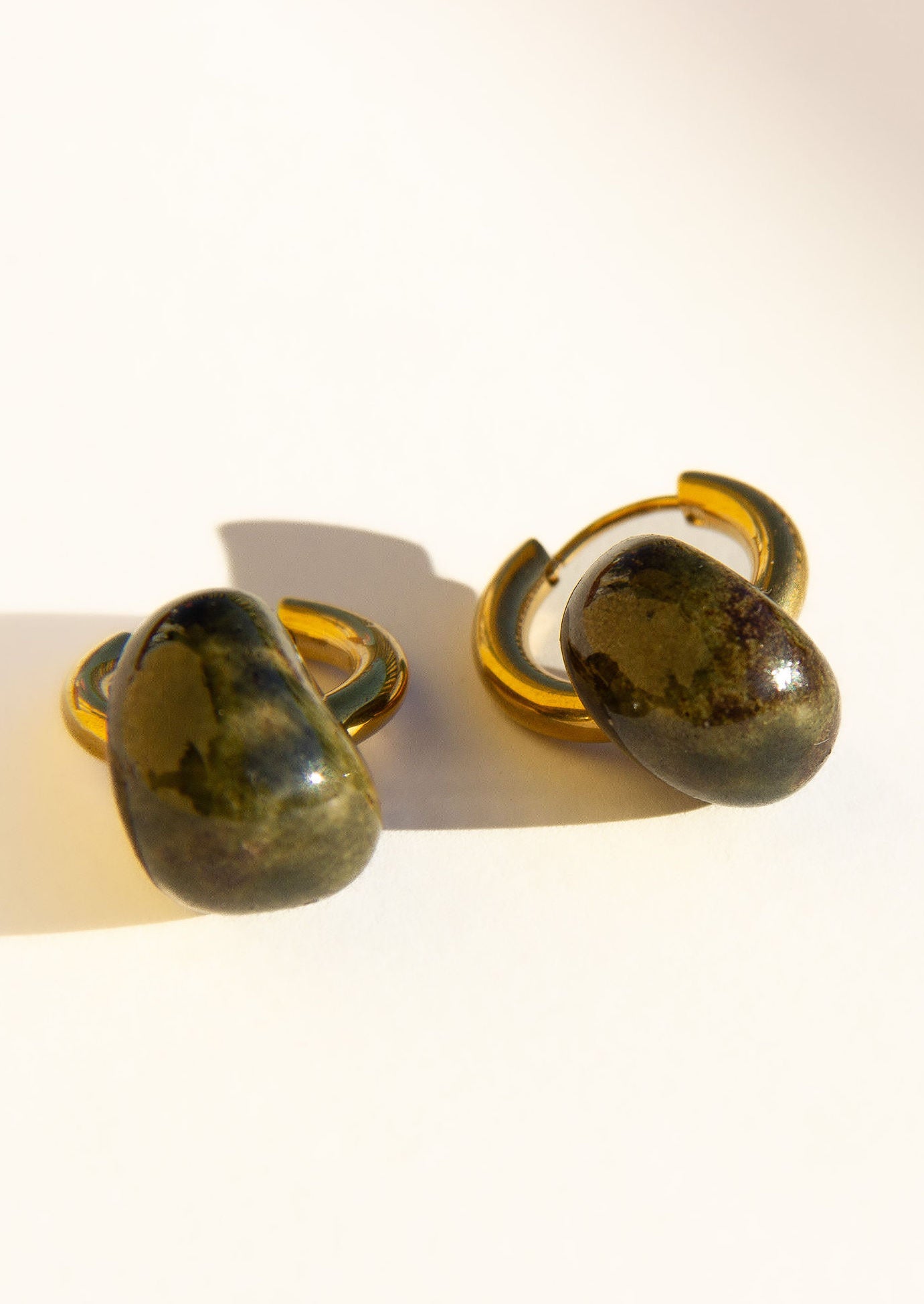 Gomes handmade ceramic earrings in Dark Green, glossy glaze — rounded circular form, bold yet discreet, deep forest green glaze, made in Lisbon Portugal by Jadeo Studio