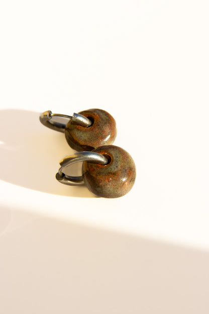 Gomes handmade ceramic earrings in Grey Green — rounded circular form, bold yet discreet, muted green-grey glaze, made in Lisbon Portugal by Jadeo Studio