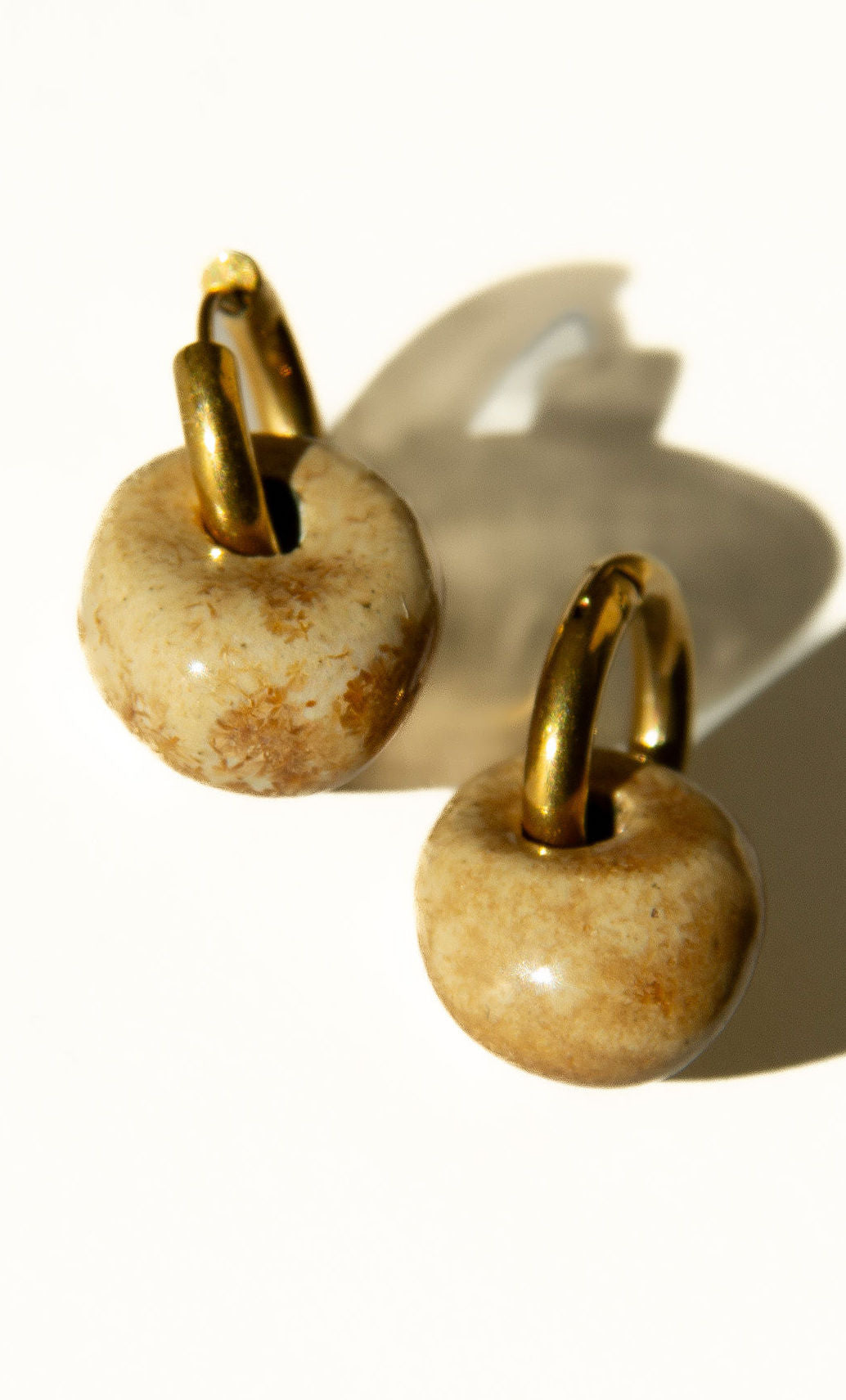 Gomes handmade ceramic earrings in Light Beige, glossy glaze — rounded circular form, bold yet discreet, made in Lisbon Portugal by Jadeo Studio