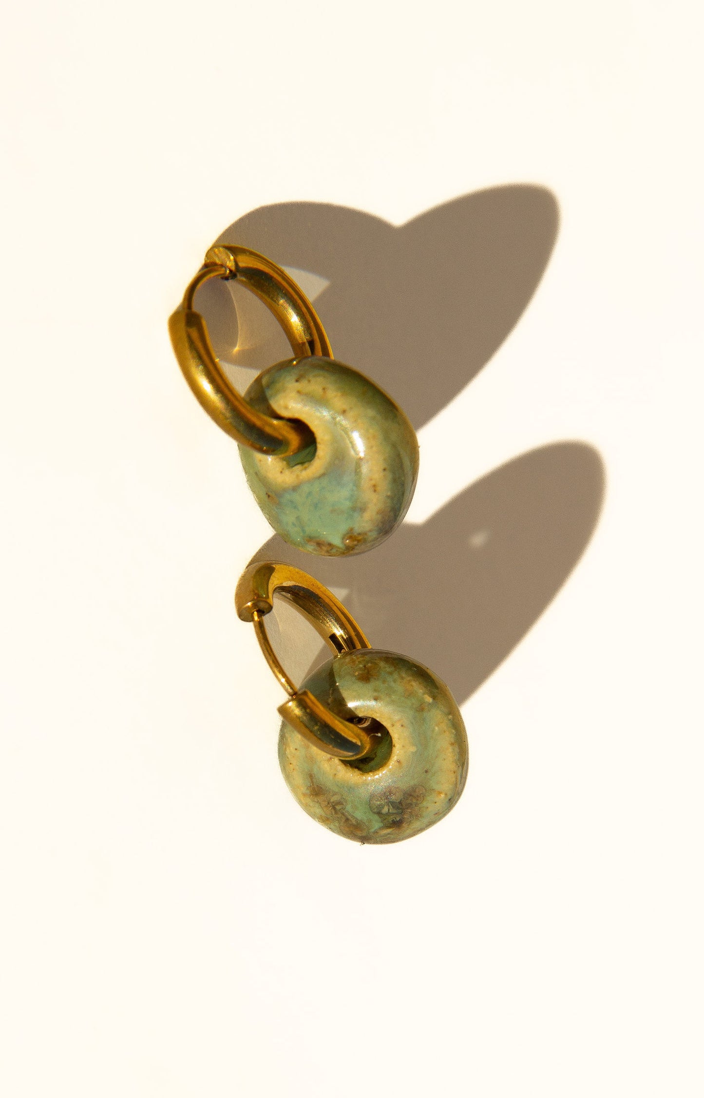 Gomes handmade ceramic earrings in Light Green, glossy glaze — rounded circular form, bold yet discreet, made in Lisbon Portugal by Jadeo Studio