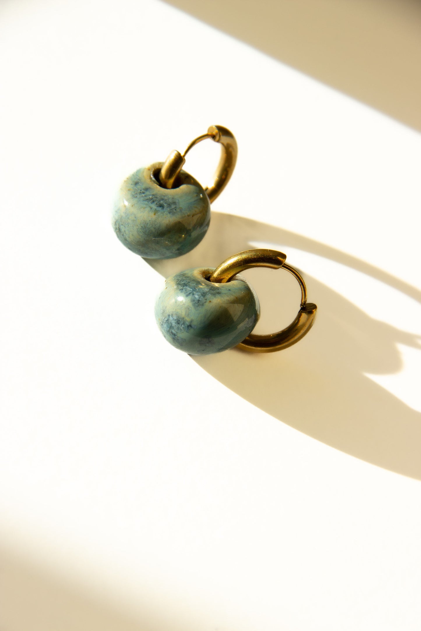 Gomes handmade ceramic earrings in Sparkling Blue — rounded circular form, bold yet discreet, made in Lisbon Portugal by Jadeo Studio