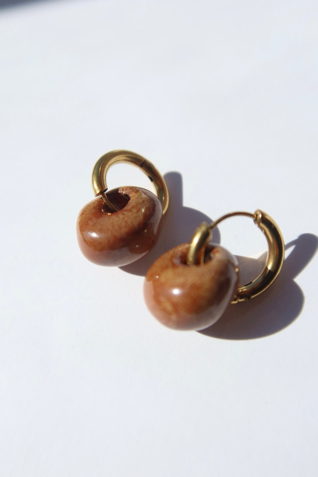 Gomes handmade ceramic earrings in Sparkling Brown, glossy glaze — rounded circular form, bold yet discreet, made in Lisbon Portugal by Jadeo Studio