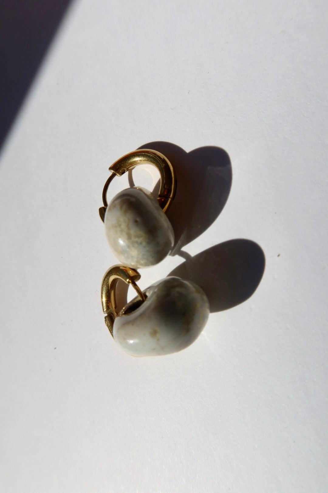 Gomes handmade ceramic earrings in Sparkling White, glossy glaze — rounded circular form, bold yet discreet, made in Lisbon Portugal by Jadeo Studio