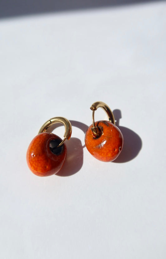 Gomes handmade ceramic earrings in Volcano on Dark Clay, glossy glaze — rounded circular form, bold yet discreet, warm earthy glaze, made in Lisbon Portugal by Jadeo Studio