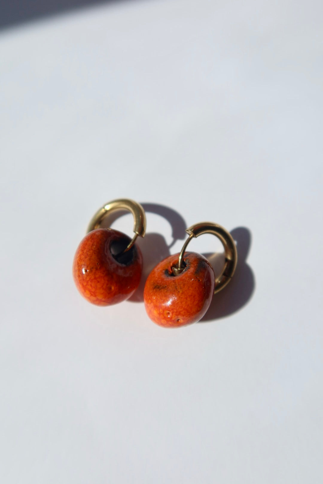 Gomes handmade ceramic earrings in Volcano on Dark Clay — rounded circular form, bold yet discreet, warm earthy glaze, statement jewlery made in Lisbon Portugal by Jadeo Studio
