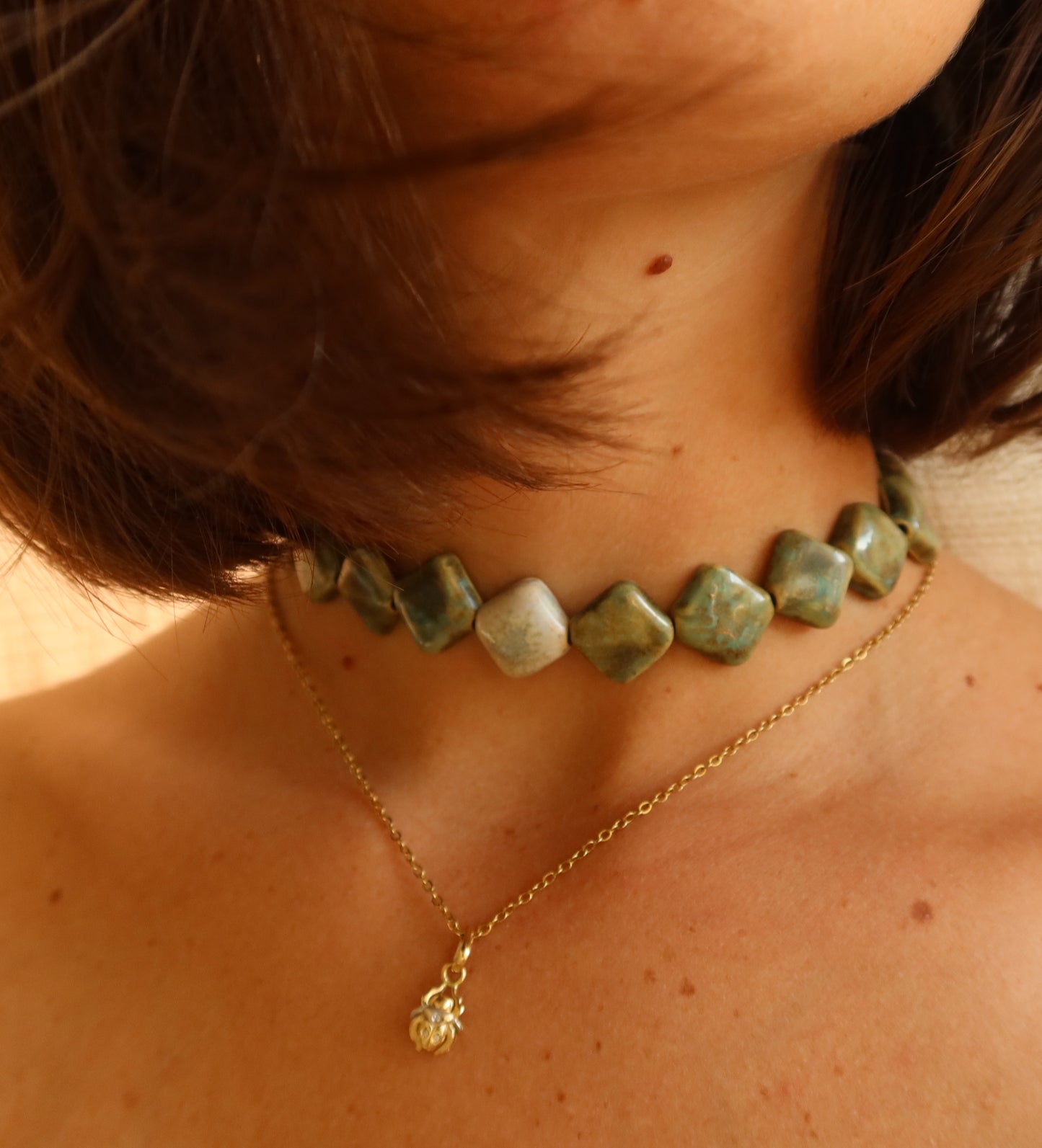 Monti handmade ceramic choker necklace in Light Green and Sparkling White worn with model with short hair — sculptural beads inspired by Roman architecture, made in Lisbon Portugal by Jadeo Studio