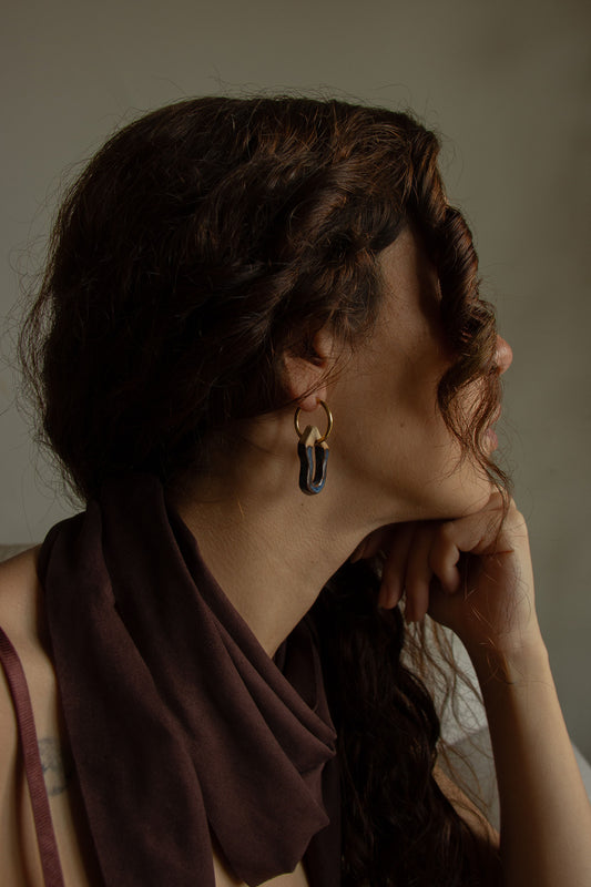 Mosca handmade ceramic earrings in Blue Jeans worn by curly hair model — organic sculpted clay with glossy glaze, made in Lisbon Portugal by Jadeo Studio