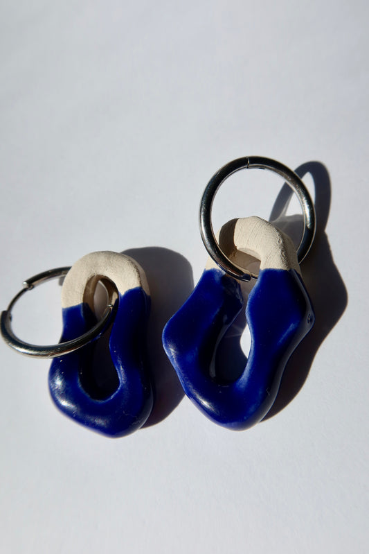 Mosca handmade ceramic earrings in Blue Navy — organic sculpted clay with glossy glaze, pair shown in natural light with strong shadow, made in Lisbon Portugal by Jadeo Studio