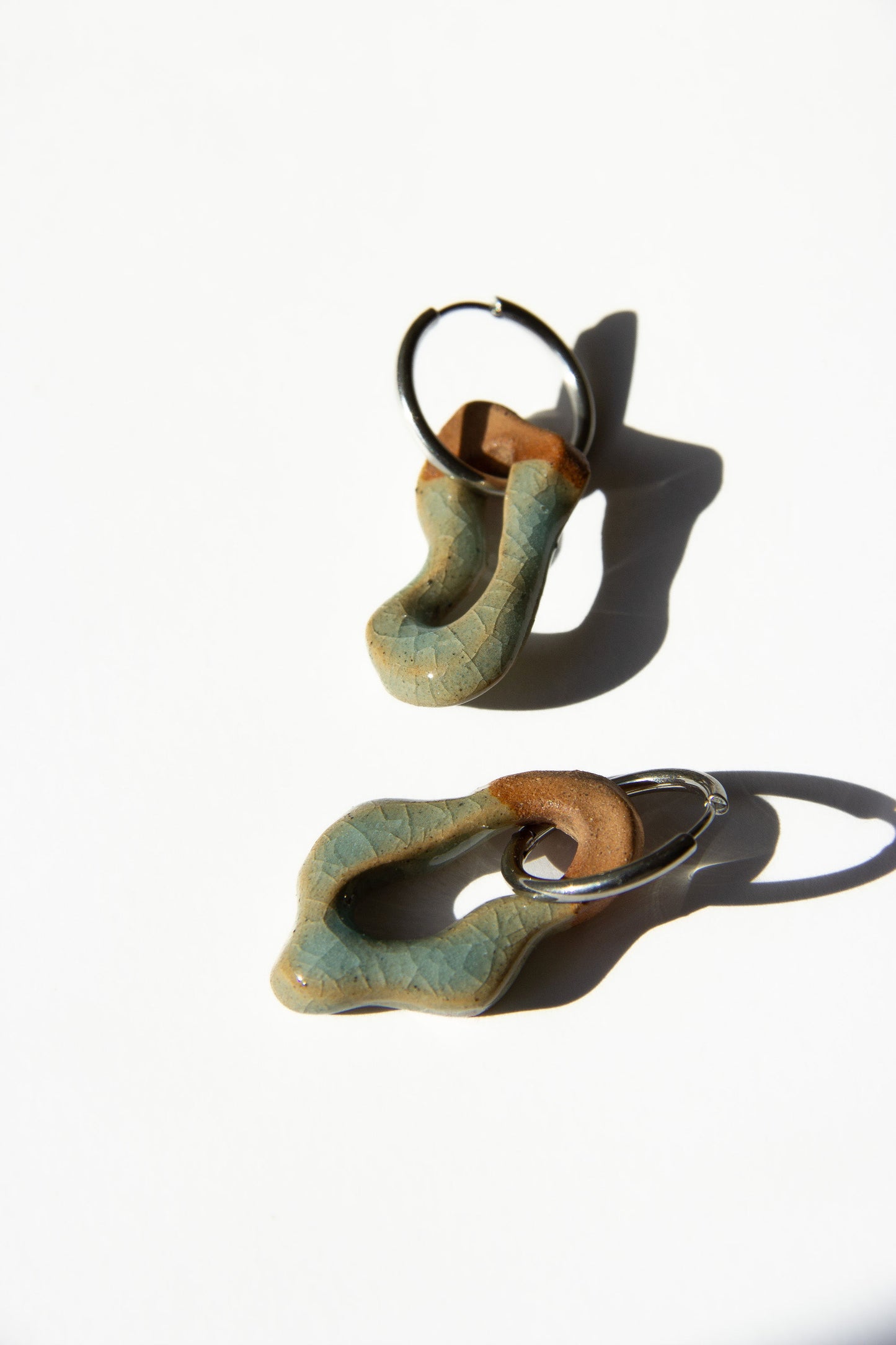 Mosca handmade ceramic earrings in Crackled Light Blue — organic sculpted clay with glossy crackled glaze, statement jewelry made in Lisbon Portugal by Jadeo Studio