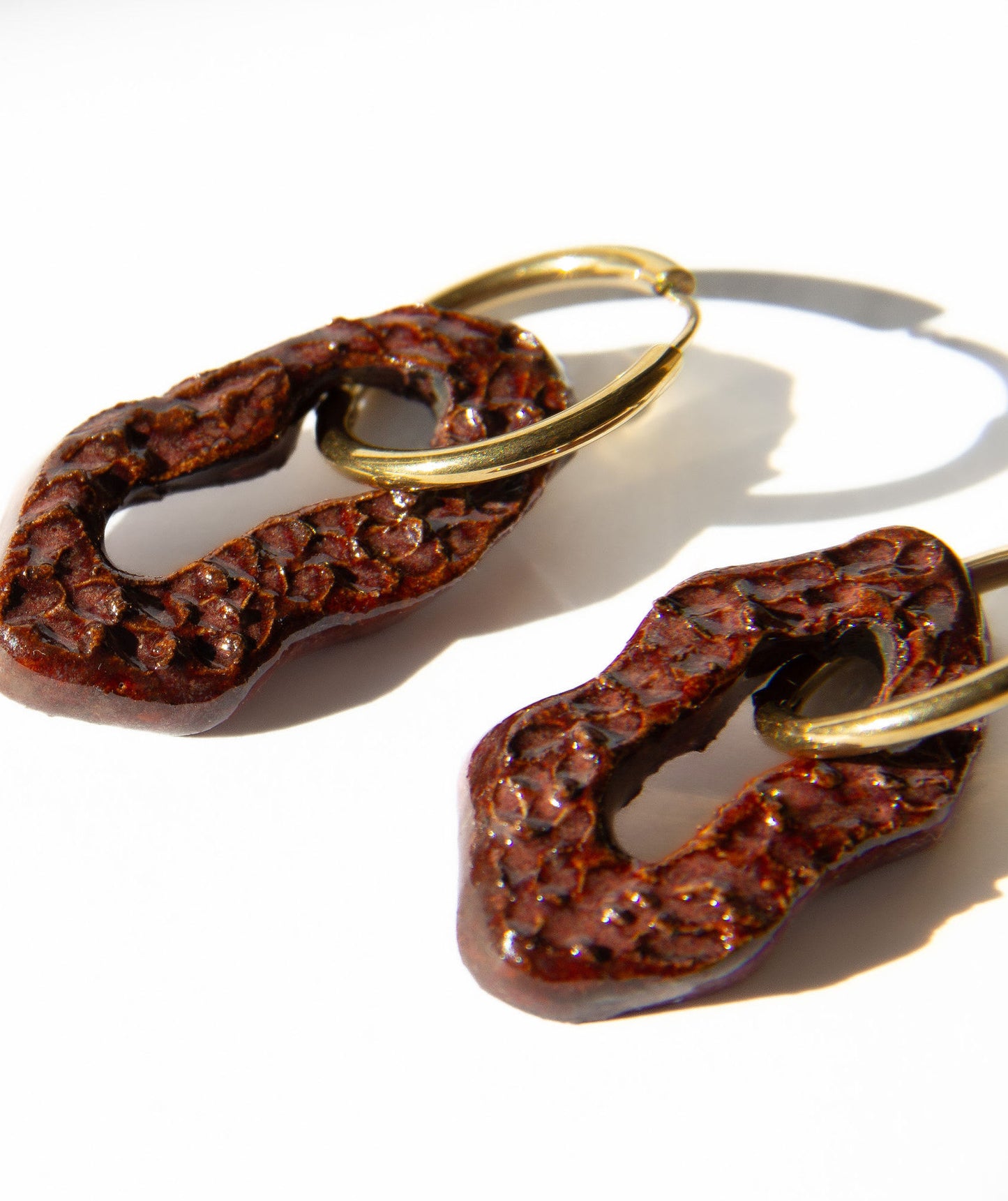 Mosca handmade ceramic earrings in Dotted Burgundy — organic sculpted clay with glossy glaze and dotted texture, statement jewelry made in Lisbon Portugal by Jadeo Studio