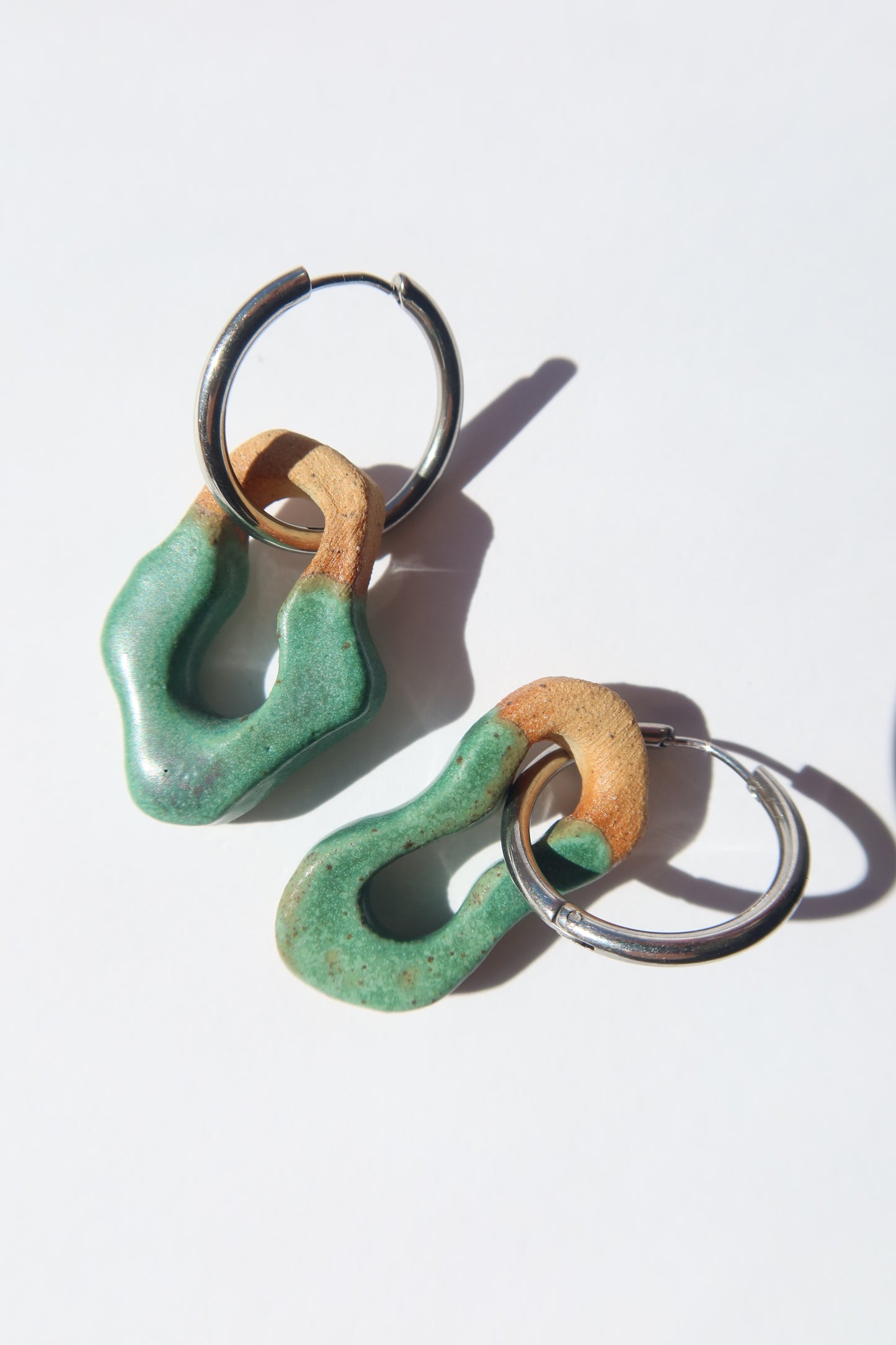 Mosca handmade ceramic earrings in Green Mat — organic sculpted clay with glossy glaze, pair shown in natural light, made in Lisbon Portugal by Jadeo Studio