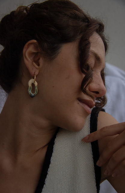 Mosca handmade ceramic earrings in Light Green worn by curly hair model — organic sculpted clay with glossy glaze, made in Lisbon Portugal by Jadeo Studio