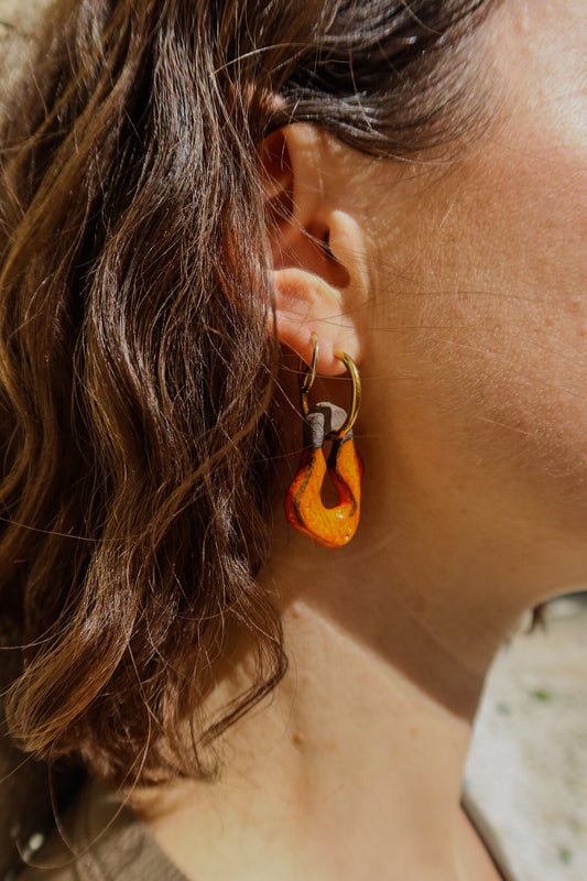 Mosca handmade ceramic earrings in Volcano on Dark Clay worn by curly hair model — organic sculpted clay with glossy glaze, made in Lisbon Portugal by Jadeo Studio