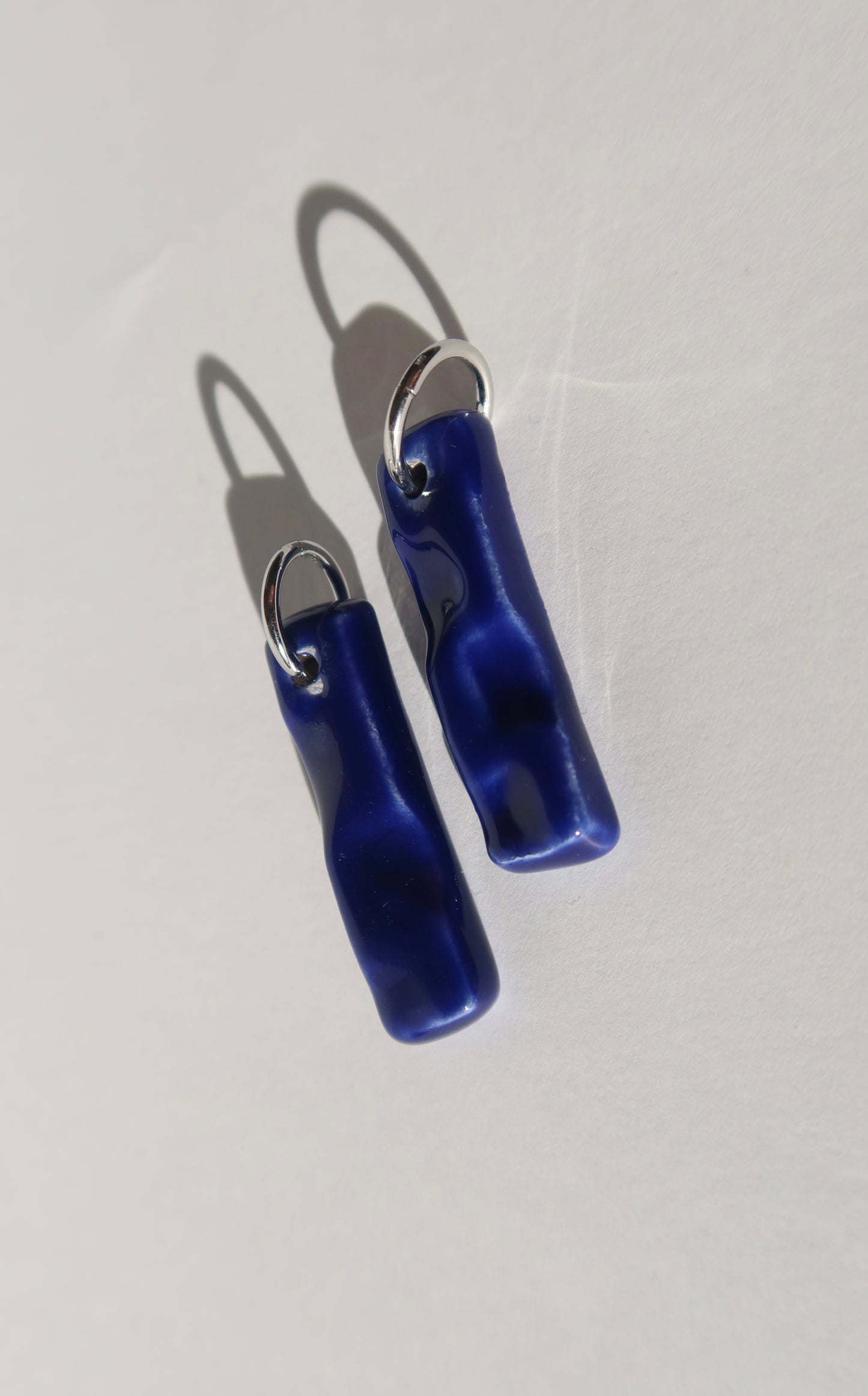 Penha handmade ceramic earrings in Blue Navy — minimalist rectangular drop, sculpted clay, made in Lisbon Portugal by Jadeo Studio, silver and gold hoop