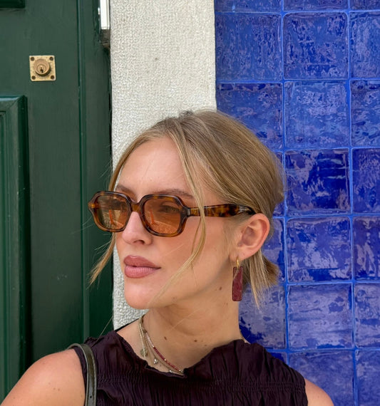 Penha handmade ceramic earrings in Brown Red, worn by blond hair model — minimalist rectangular drop, sculpted clay, made in Lisbon Portugal by Jadeo Studio