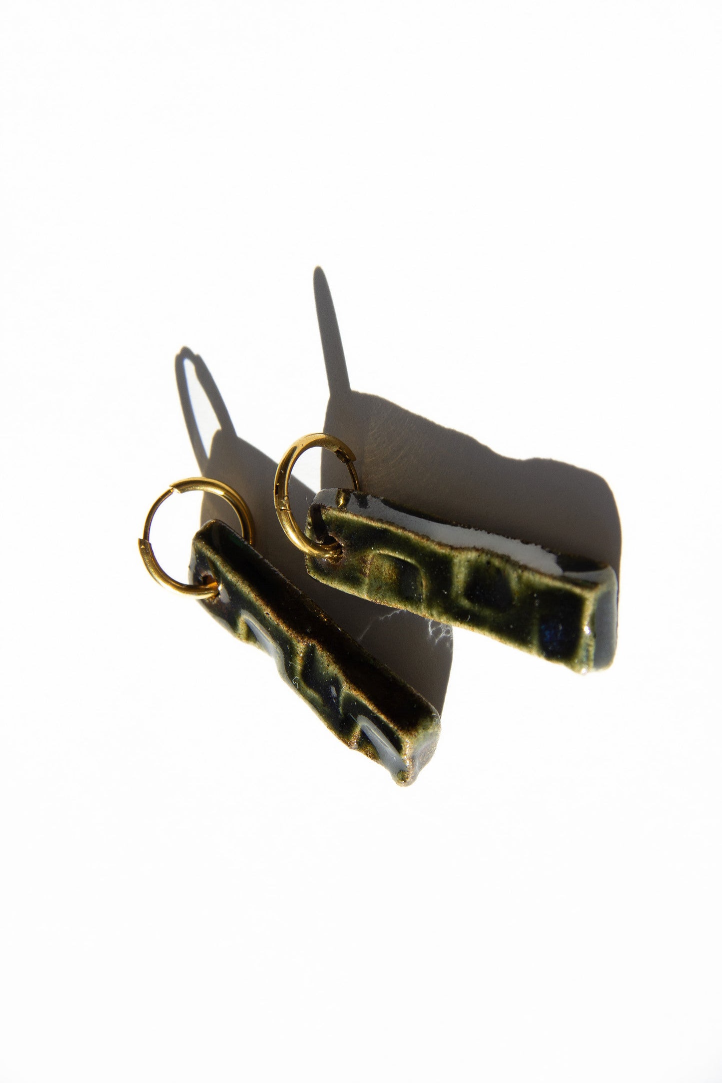 Penha handmade ceramic earrings in Dark Green — minimalist rectangular drop, sculpted clay, made in Lisbon Portugal by Jadeo Studio, silver and gold hoop