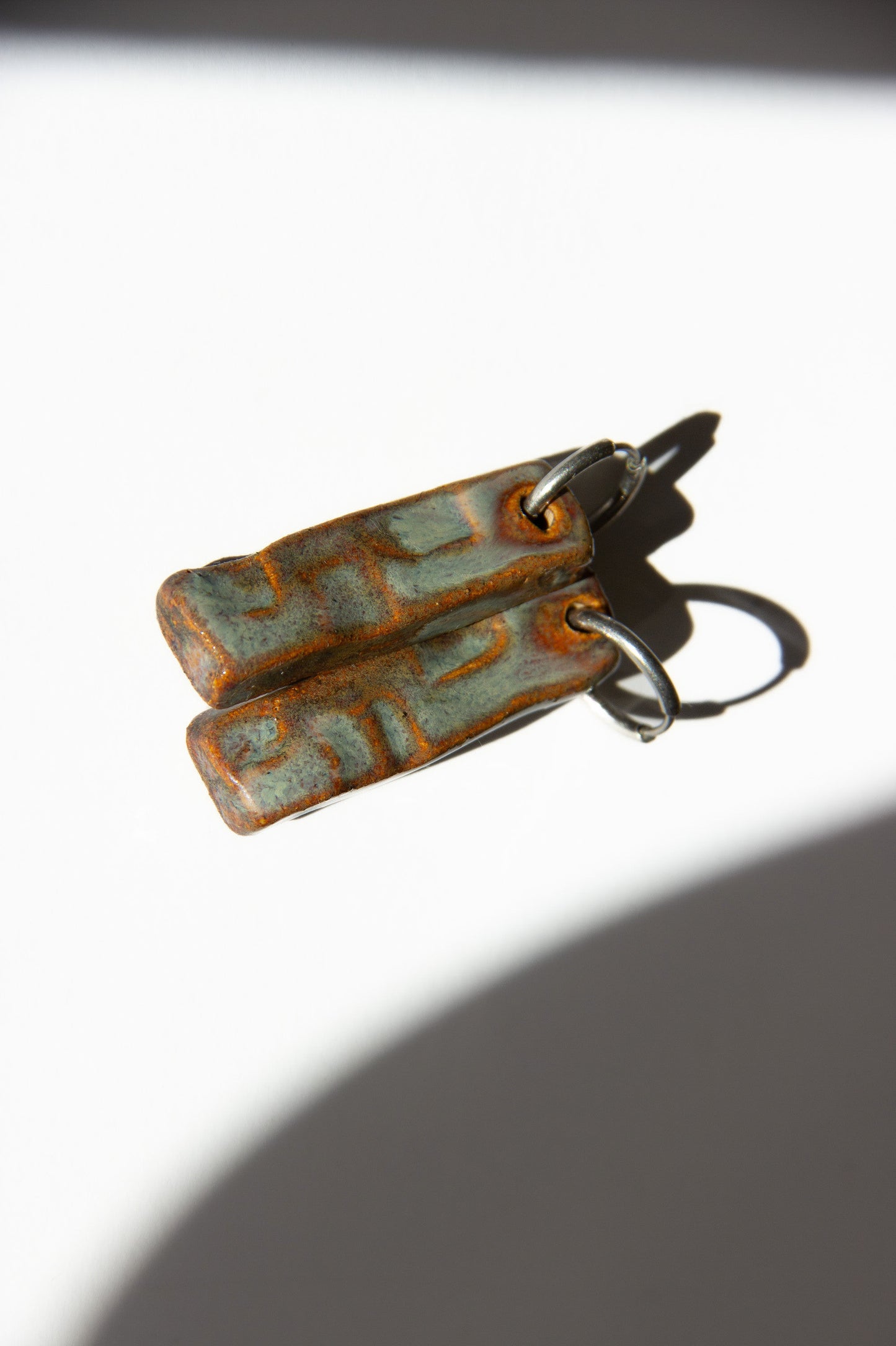 Penha handmade ceramic earrings in Grey Green, glossy glaze — minimalist rectangular drop, sculpted clay, made in Lisbon Portugal by Jadeo Studio
