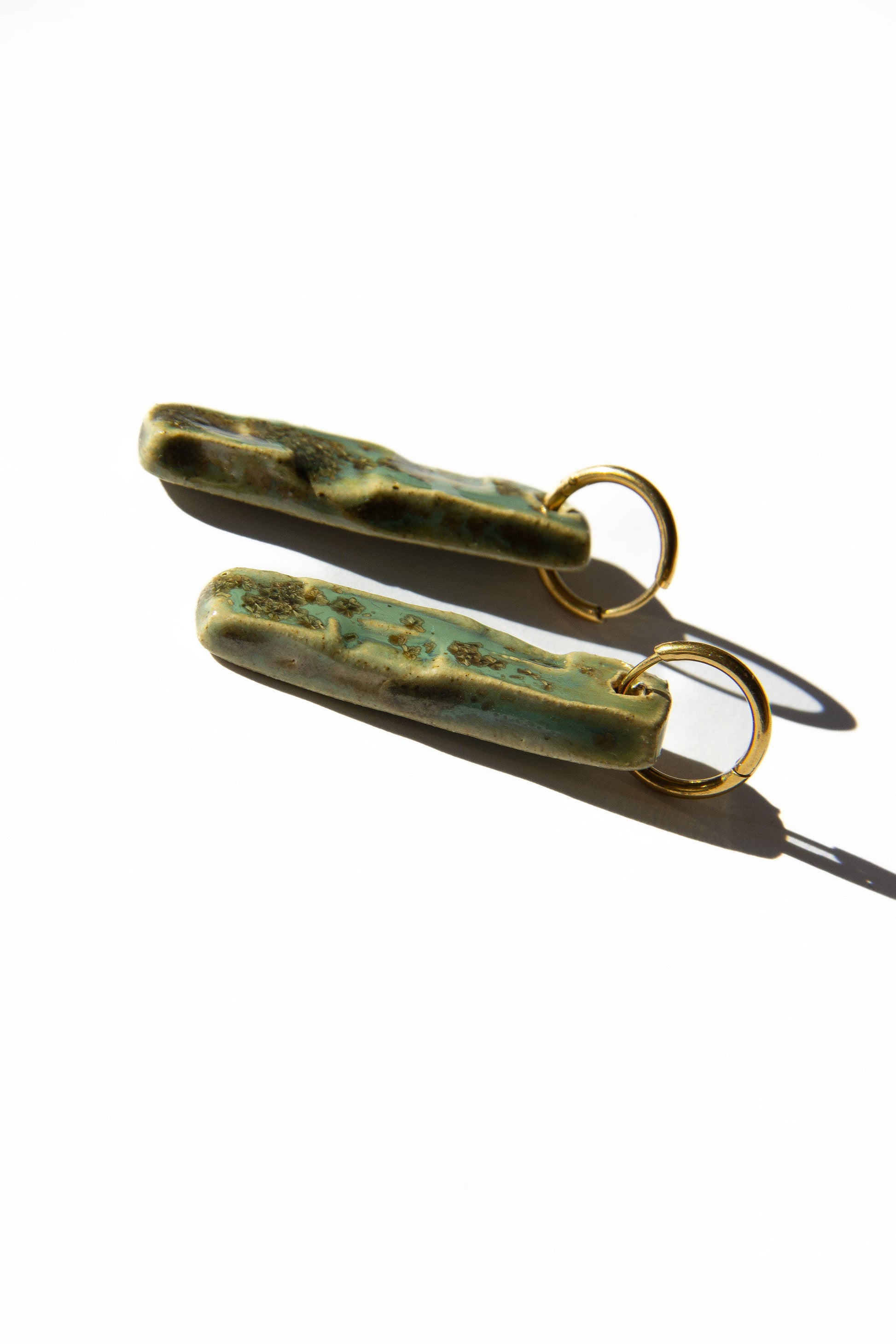 Penha handmade ceramic earrings in Light Green, glossy glaze — minimalist rectangular drop, sculpted clay, made in Lisbon Portugal by Jadeo Studio