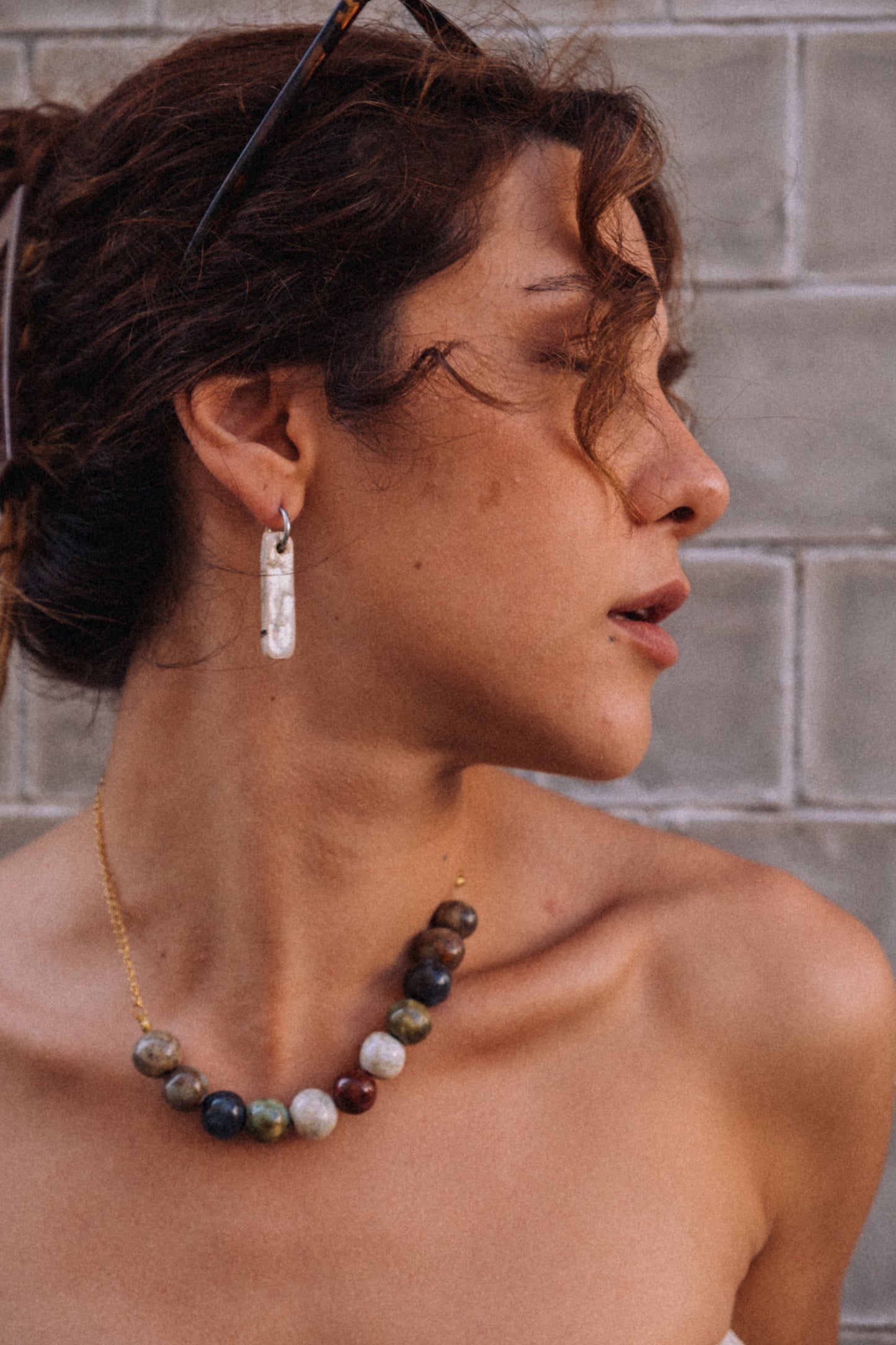 Penha handmade ceramic earrings in Sparkling White on soft skin — minimalist rectangular drop, sculpted clay, made in Lisbon Portugal by Jadeo Studio
