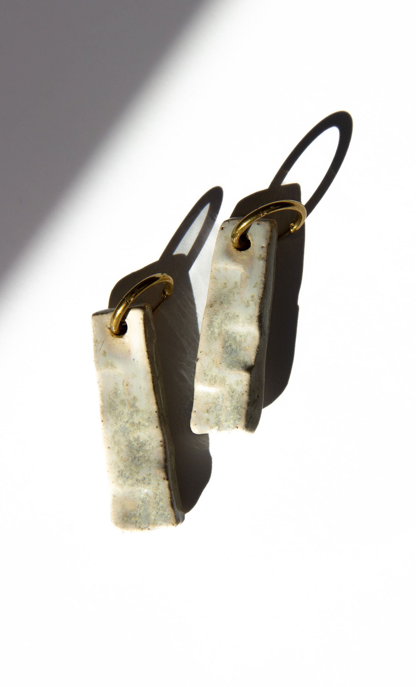 Penha handmade ceramic earrings in Sparkling White — minimalist rectangular drop, sculpted clay, made in Lisbon Portugal by Jadeo Studio, silver and gold hoop